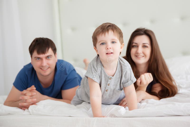 Little boy and parents On Parents Bed Wearing Pajamas royalty free stock photos Little boy and parents On Parents Bed Wearing Pajamas royalty free stock photos