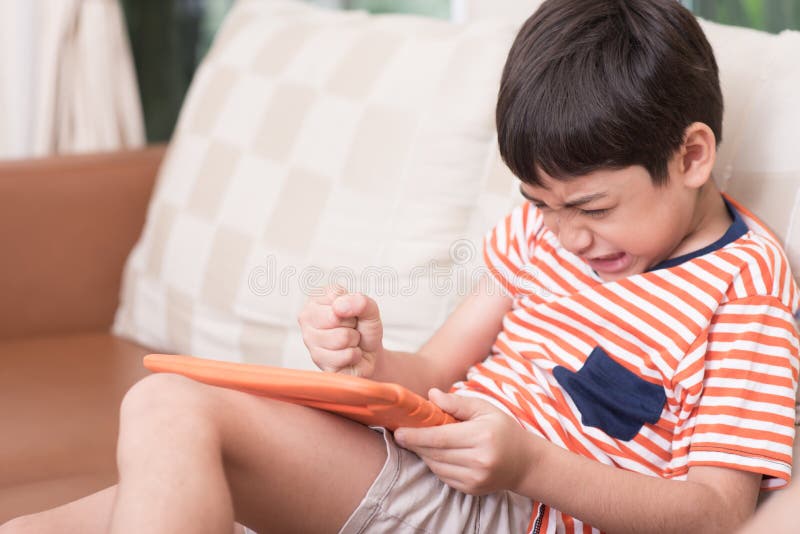 Little boy play game tablet with angry feeling