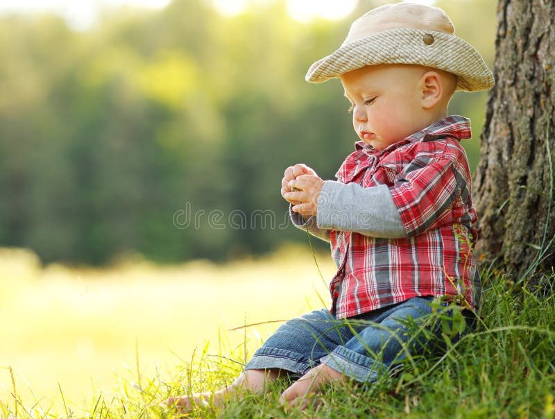 Little boy playing cowboy in nature