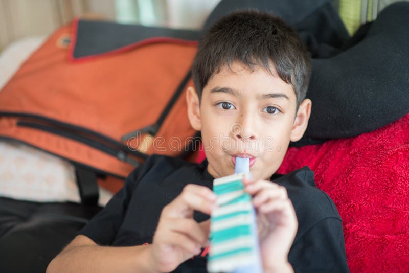 Little boy playing flute lay down on the bed royalty free stock image