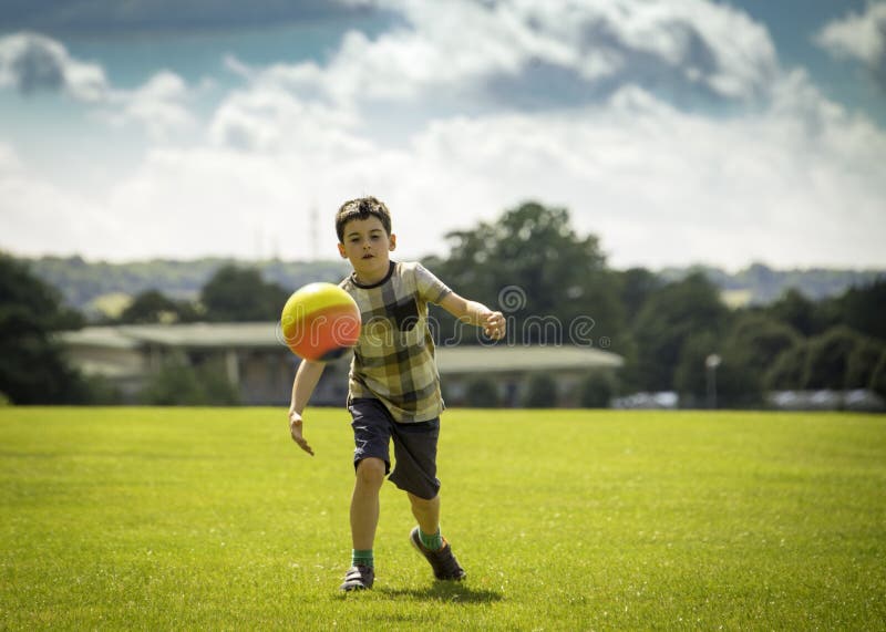 Foto scattata di 7 anni che giocano a calcio in una giornata calda e soleggiata a Stoke Park, Guildford.