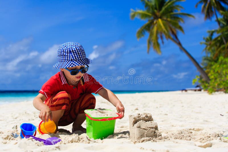 Little boy playing with sand on the beach