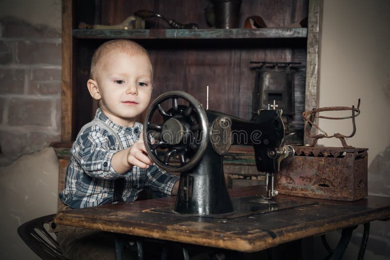 Little boy playing with sewing-machine