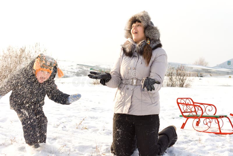 Little boy playing in the snow with Mother