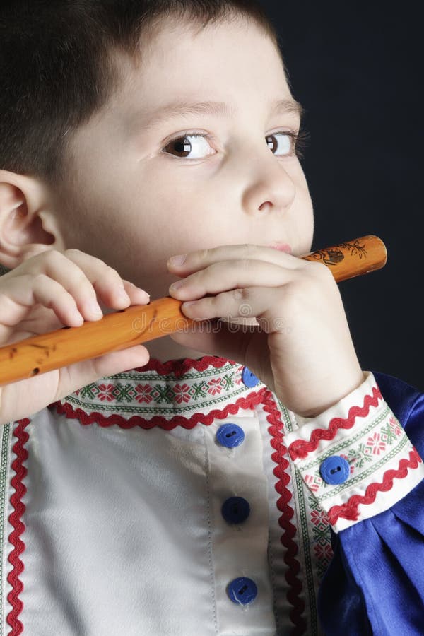 Little boy playing wooden flute stock photography