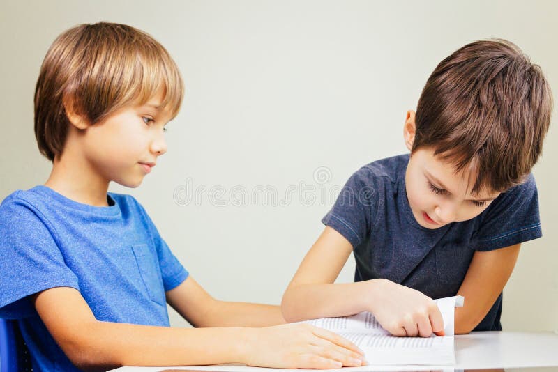 Little boy practice reading with his brother at home stock photo Little boy practice reading with his brother at home stock photo