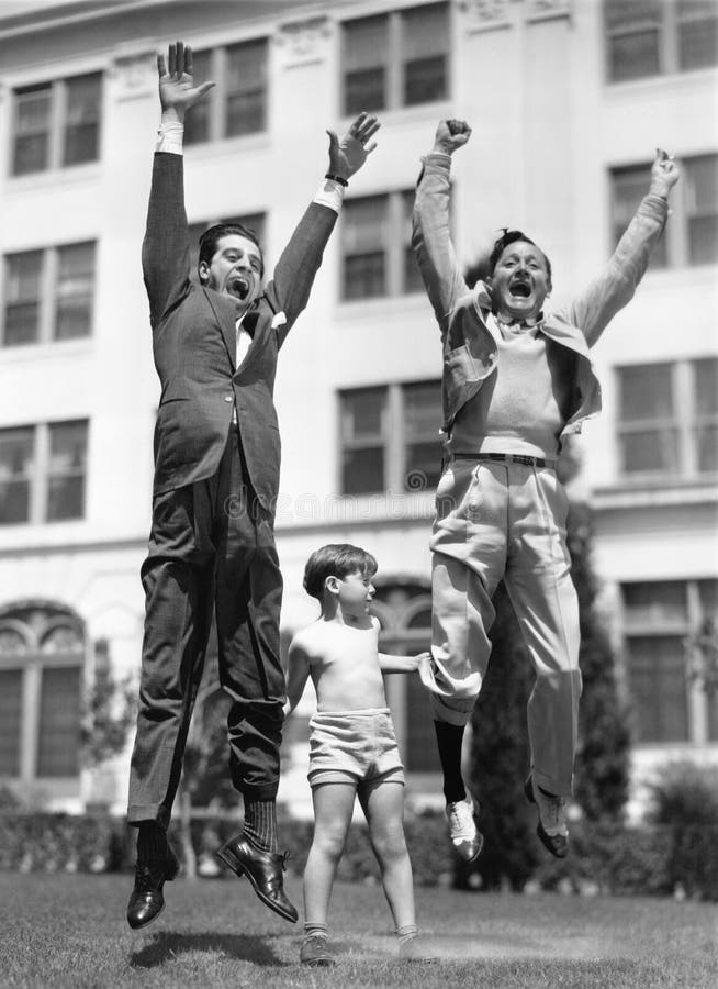 A little boy pretending to lift two grown men