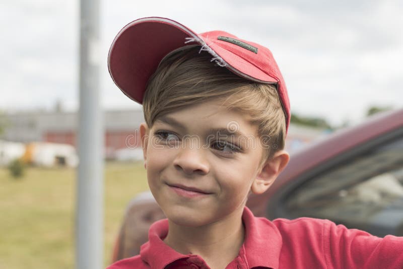 A little boy in a red t-shirt and cap