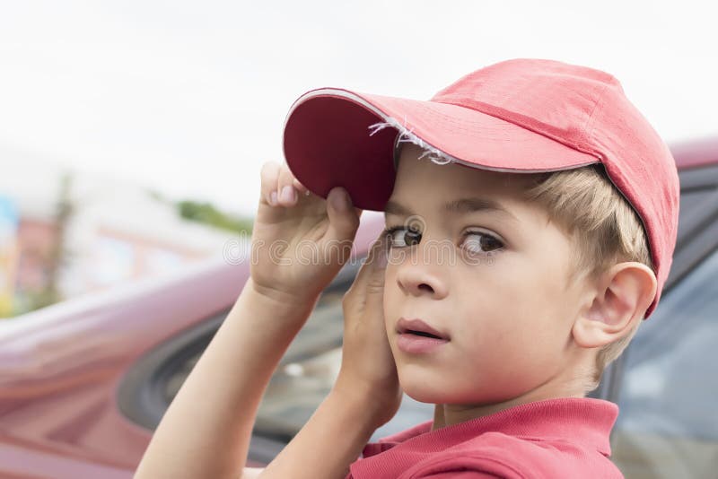 A little boy in a red t-shirt and cap