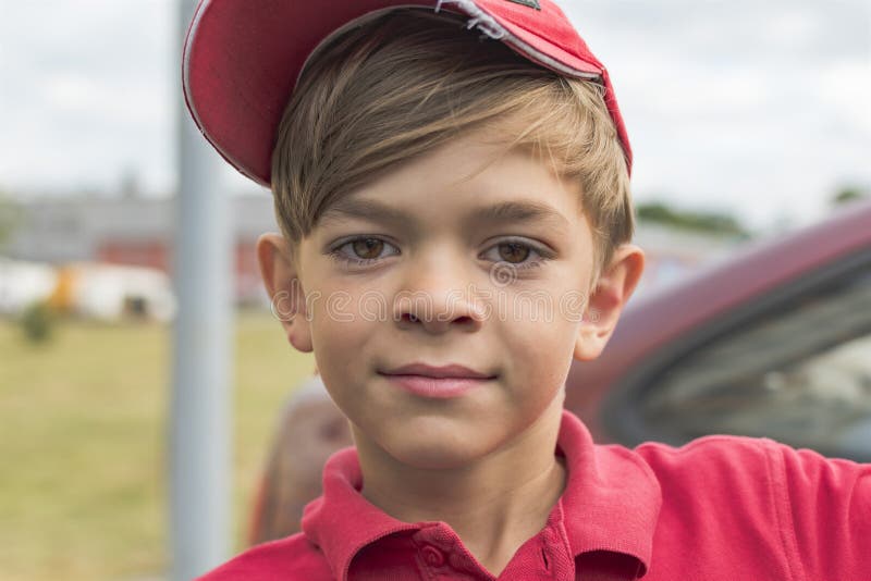 A little boy in a red t-shirt and cap