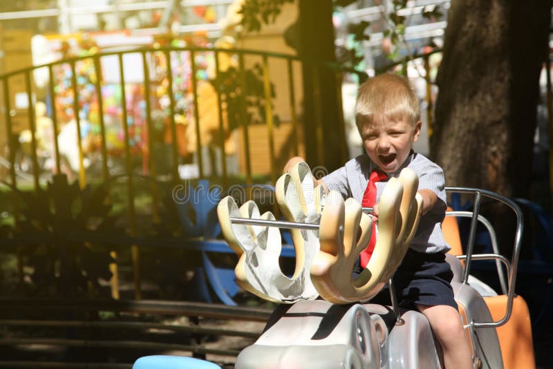 little boy with a red tie riding a carousel royalty free stock image little boy with a red tie riding a carousel royalty free stock image