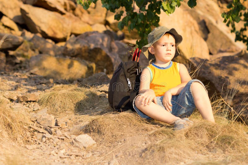 Little boy resting with his rucksack