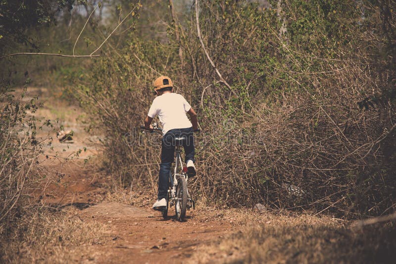 Little boy ride bicycle on the rock road. royalty free stock photos Little boy ride bicycle on the rock road. royalty free stock photos