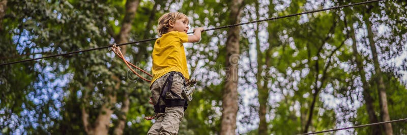 Little boy in a rope park. Active physical recreation of the child in the fresh air in the park. Training for children stock photography Little boy in a rope park. Active physical recreation of the child in the fresh air in the park. Training for children stock photography