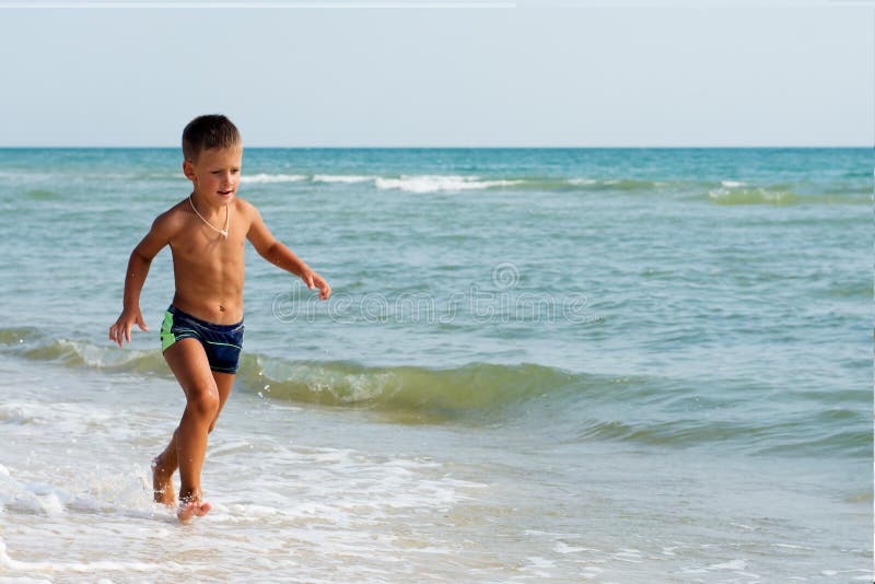 Little boy running in summer at sea beach