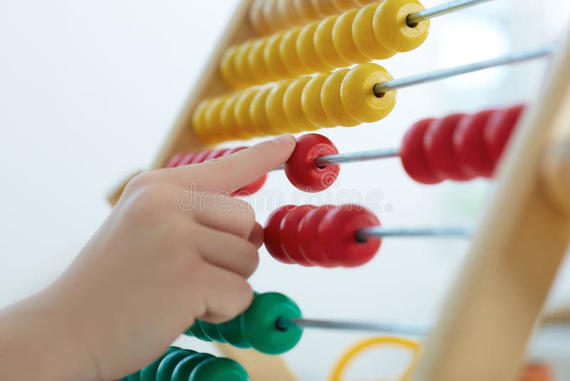 Little boy`s hand playing with counter toy closeup. The concept of early education.