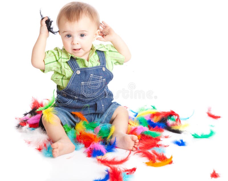 Little boy is sitting on a flow with feathers