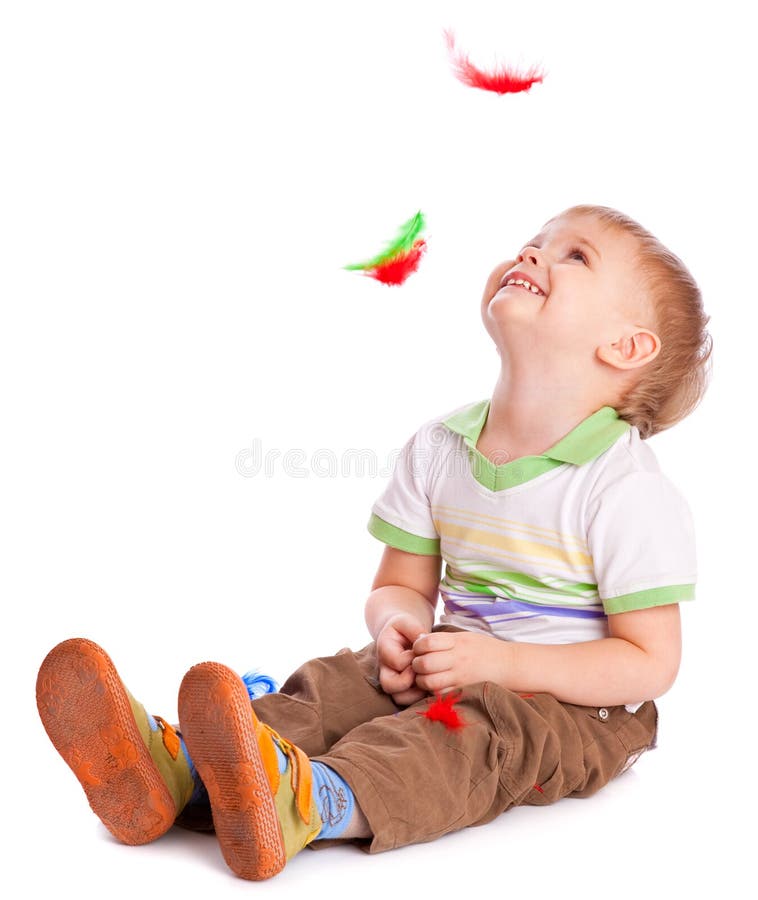 Little boy is sitting on a flow with feathers