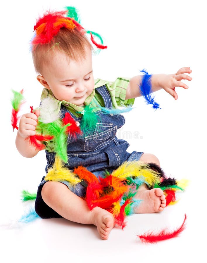 Little boy is sitting on a flow with feathers