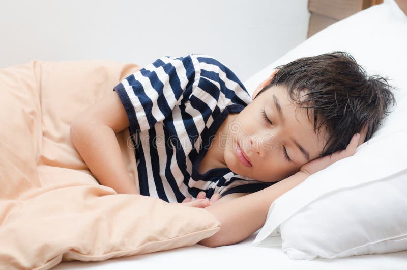 Little boy sleeping on bed