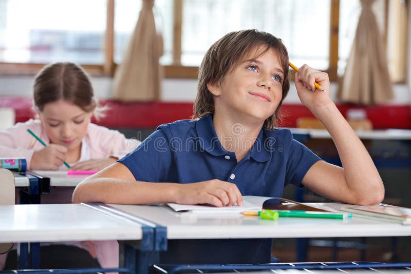 Little Boy Smiling While Looking Up In Classroom stock photos