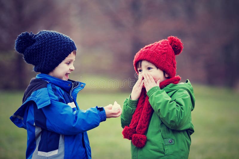 Little boy, sneezing and blowing his nose on a sunny winter day