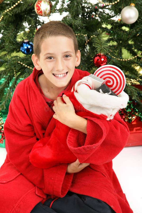 Little Boy sob a árvore de Natal com meia fotografia de stock royalty free Little Boy sob a árvore de Natal com meia fotografia de stock royalty free
