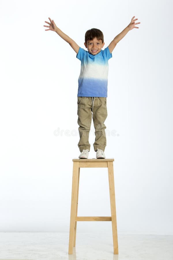 Little boy standing on a high stool