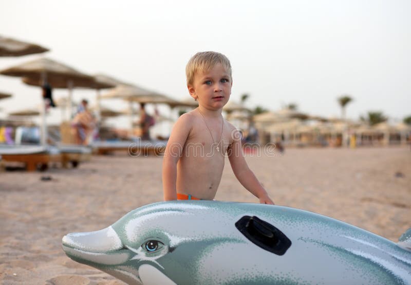 Little boy standing on the sand on the beach