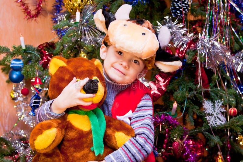 Little boy in the suit of bull-calf near a new-year tree. Kid calf stock images, royalty-free photos and pictures