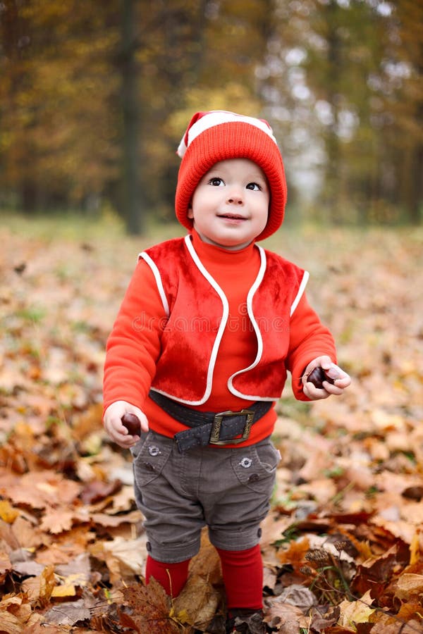 Little Boy in a Suit with a Pumpkin Gnome in Autumn Park Stock Photo