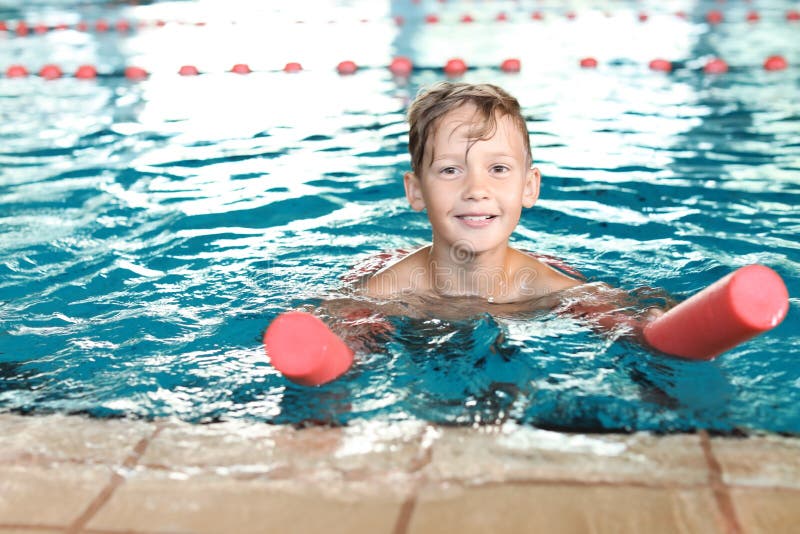 Little boy with swimming noodle in pool stock photography Little boy with swimming noodle in pool stock photography