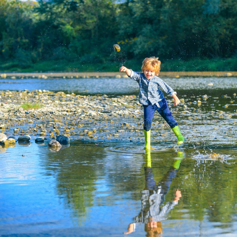 Little boy throw stones at the Stony river. Beautiful kids girl throws a rock at the river. Skipping Rocks. Boy traveling away from home. Adventure and vacations children concept