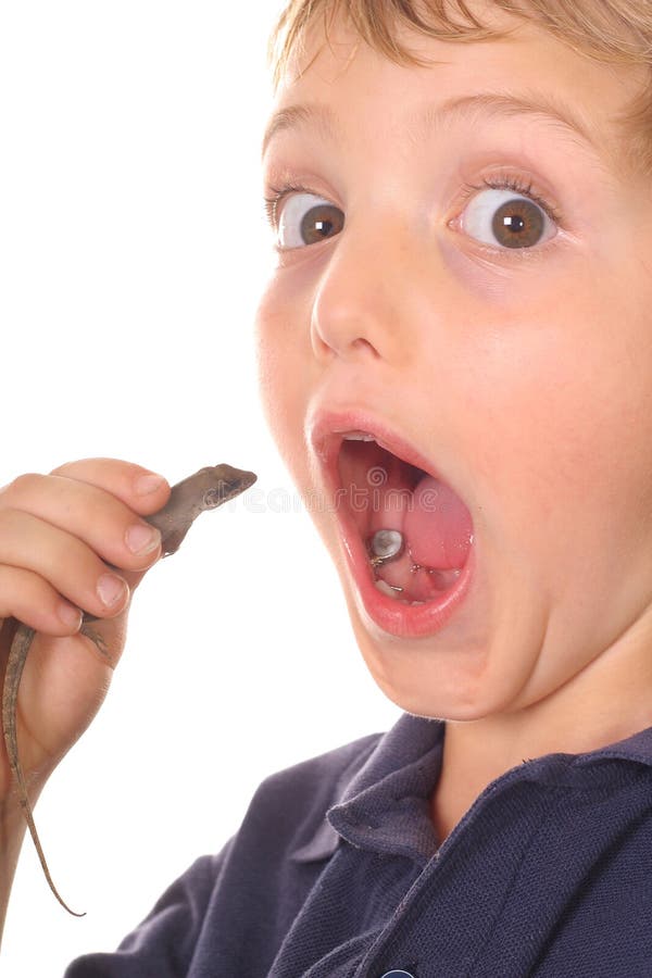 Little boy about to eat a lizard