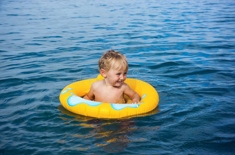 Little boy in water on rubber ring stock photo
