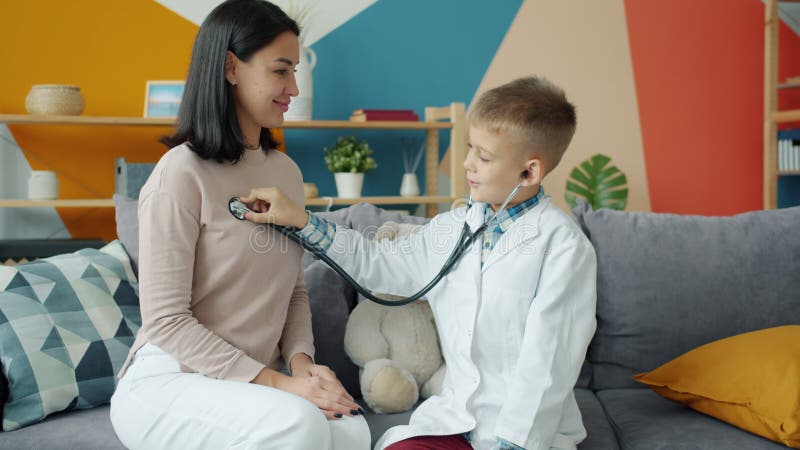 Little Boy in White Gown Playing with Mom Examining Her with Stethoscope Stock Video - Video of doctor, examination: 181121819