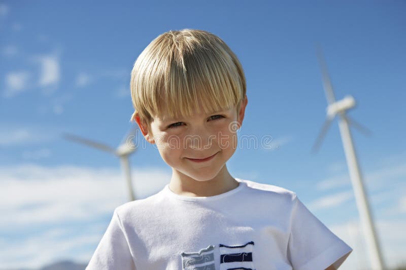 Little Boy Z silnikami wiatrowymi W tle fotografia stock Little Boy Z silnikami wiatrowymi W tle fotografia stock