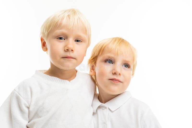 Little boys brothers with short light and red hair, blue eyes, cute appearance, in white jacket, light blue pants, stand royalty free stock photo Little boys brothers with short light and red hair, blue eyes, cute appearance, in white jacket, light blue pants, stand royalty free stock photo