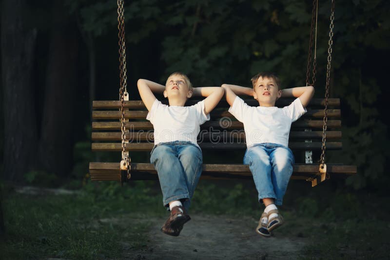 Little boys riding on a swing