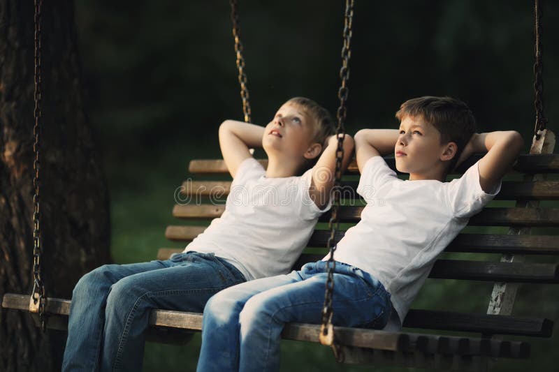 Little boys riding on a swing