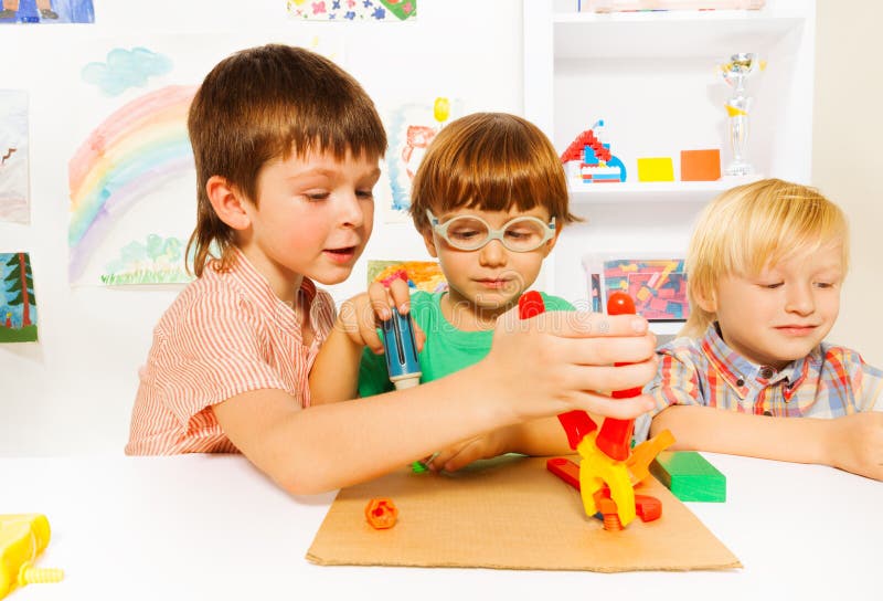 Little boys with toy pliers in classroom