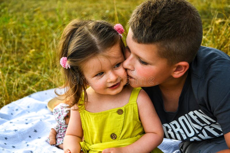 Sister and brother playing. Старшая сестра целует младшего брата. Брат и сестра поцеловались. Брат с сестрой играют в карты. Как целуются в губы дети.