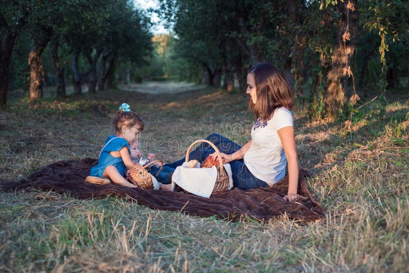 Little brother and sister sit in a row at a family picnic. Time for family stock images Little brother and sister sit in a row at a family picnic. Time for family stock images