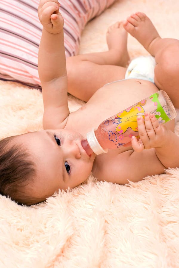 Little caucasian boy drinking from the bottle