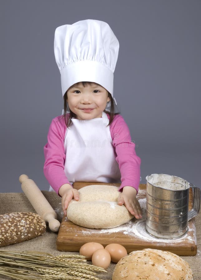 Una giovane ragazza divertirsi in cucina e fare un pasticcio.