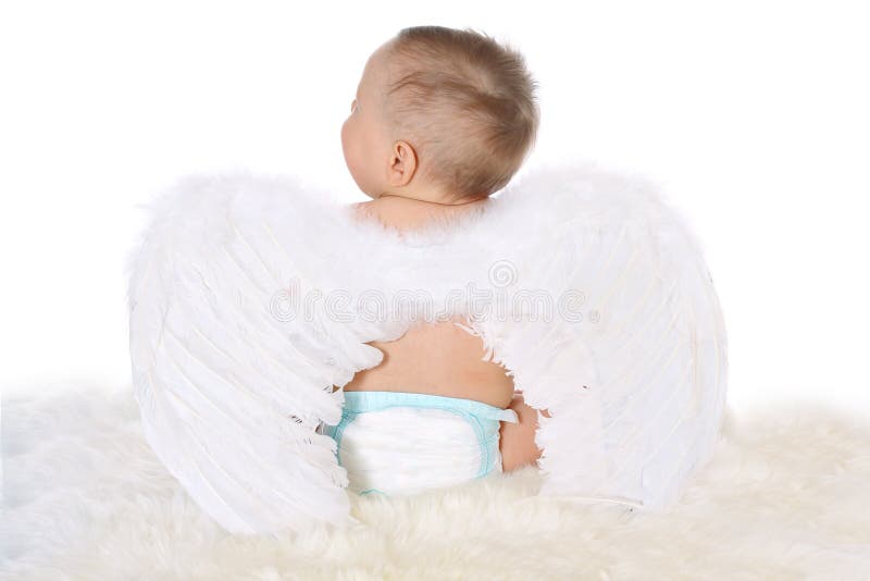 Little child with angel wings sitting back on a white fur