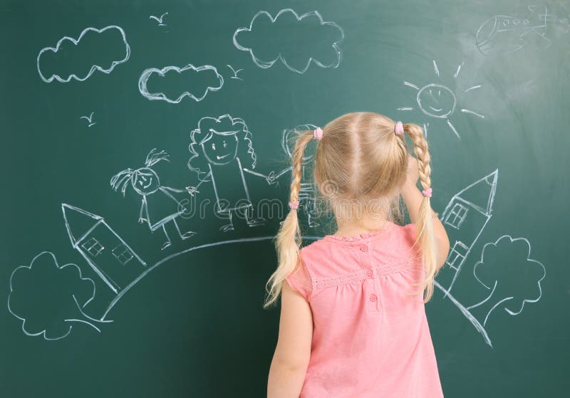 Little child drawing family with white chalk on blackboard