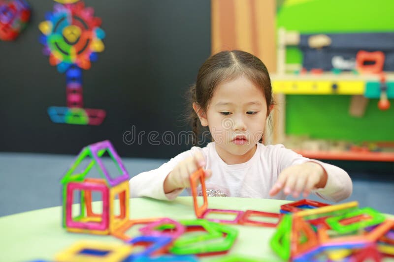 Little child girl playing Magnets toy for brain development