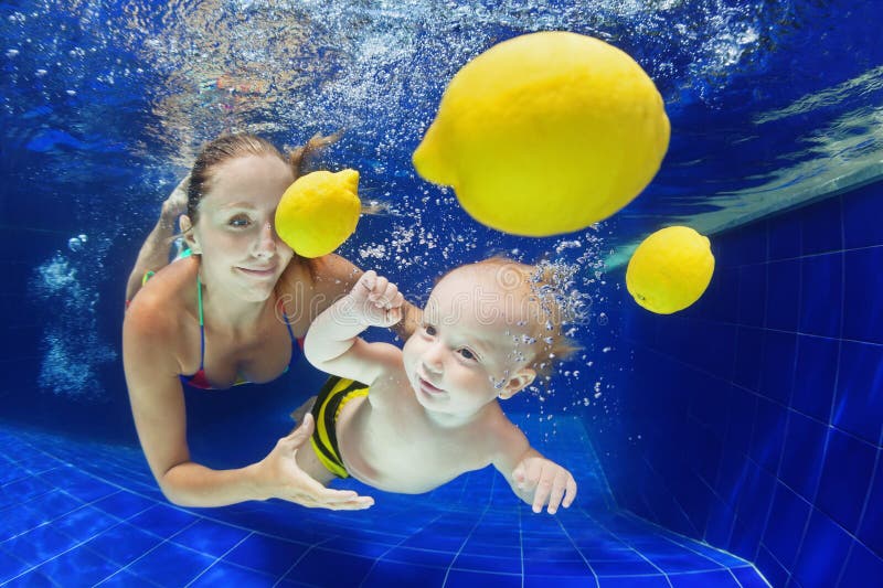 Little child with mother swimming underwater in pool