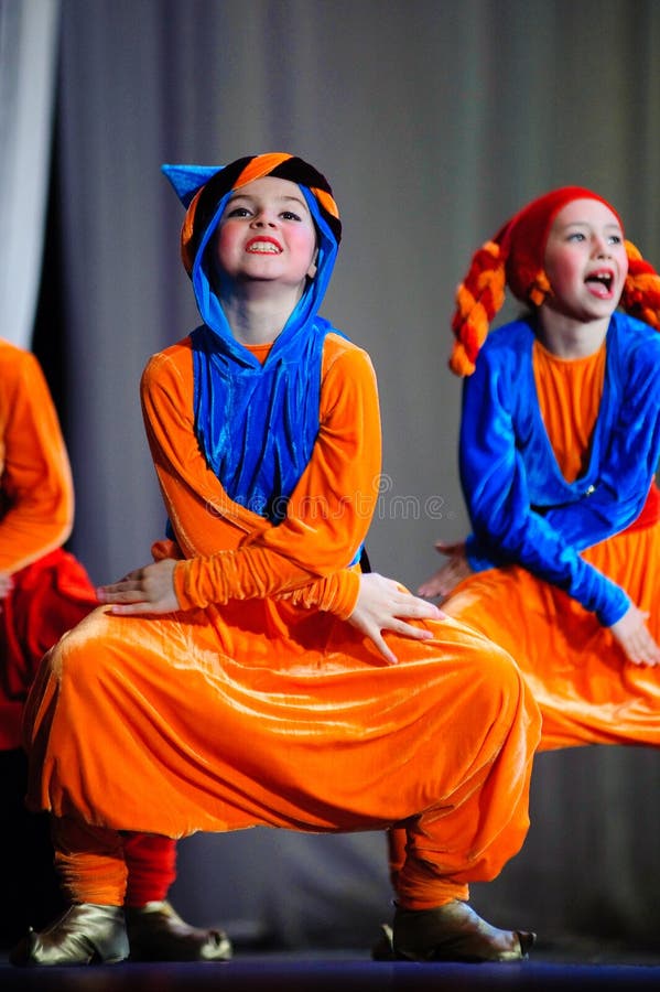 Little children dancing with old oriental costumes on stage